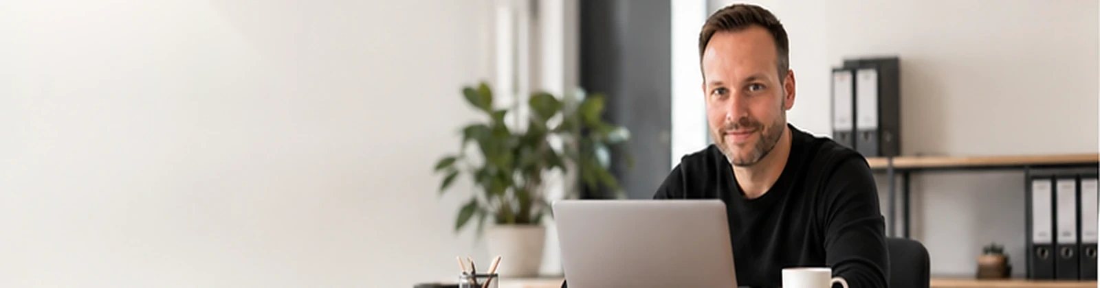 Manuel Forche, IT-Berater aus Viersen, am Schreibtisch mit Laptop